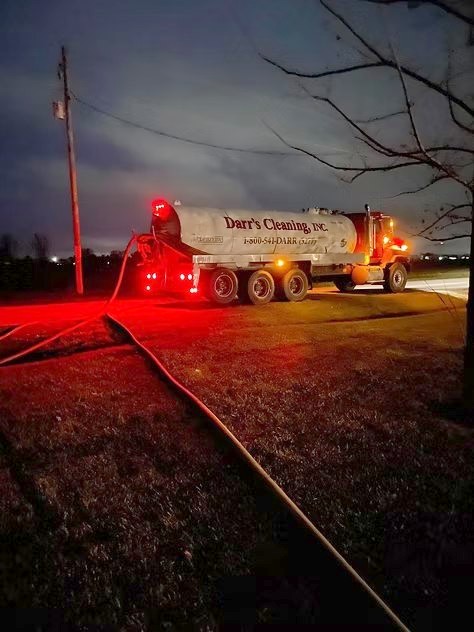 Tanker truck pumping a septic system after dark